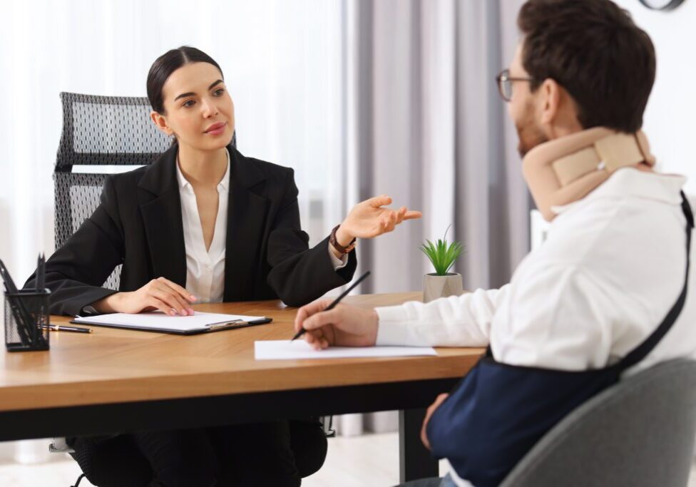 Woman and injured man in office discussion.